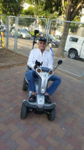 Old gentleman sitting on a blue Titan 4, one of the disability scooters